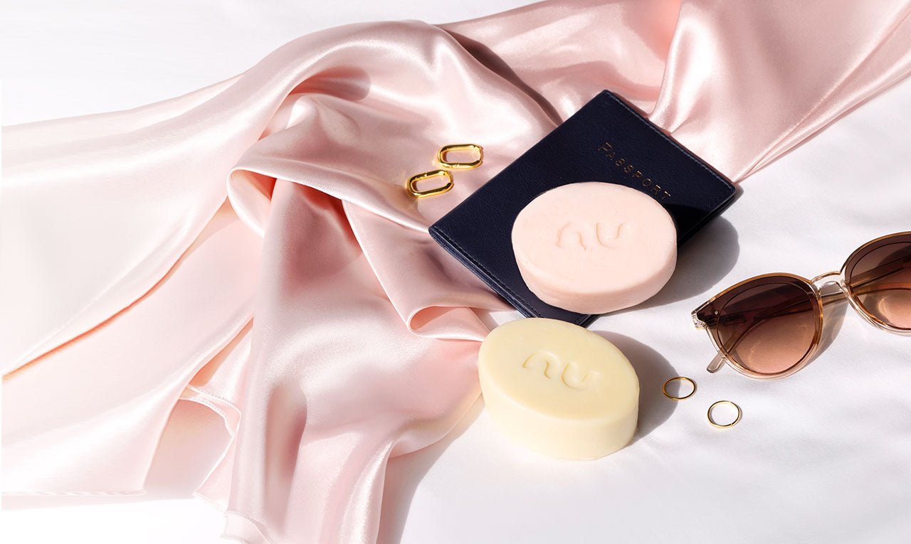 Luxurious Nu Standard™ Wash & Go™ and Hydrate N Go™ Butter Bars resting on satin fabric-- the best shampoo and conditioner bars for curly, coily, zig-zag, and wavy tresses.